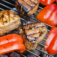 grilled steaks and peppers on the grill