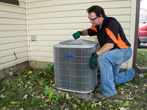 HVAC technician cleaning outdoor ac unit for air conditioning maintenance services